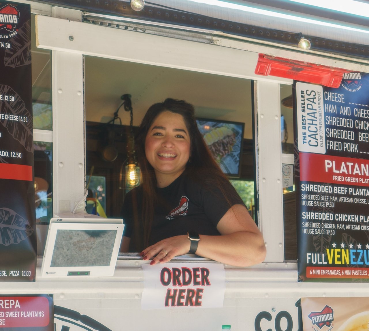 A smiling independent vendor at his food truck window